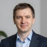 Портрет уверенного российского бизнесмена с дружелюбным взглядом на нейтральном размытом фоне в студии