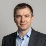Портрет уверенного российского бизнесмена с дружелюбным взглядом на размытом нейтральном фоне в студии